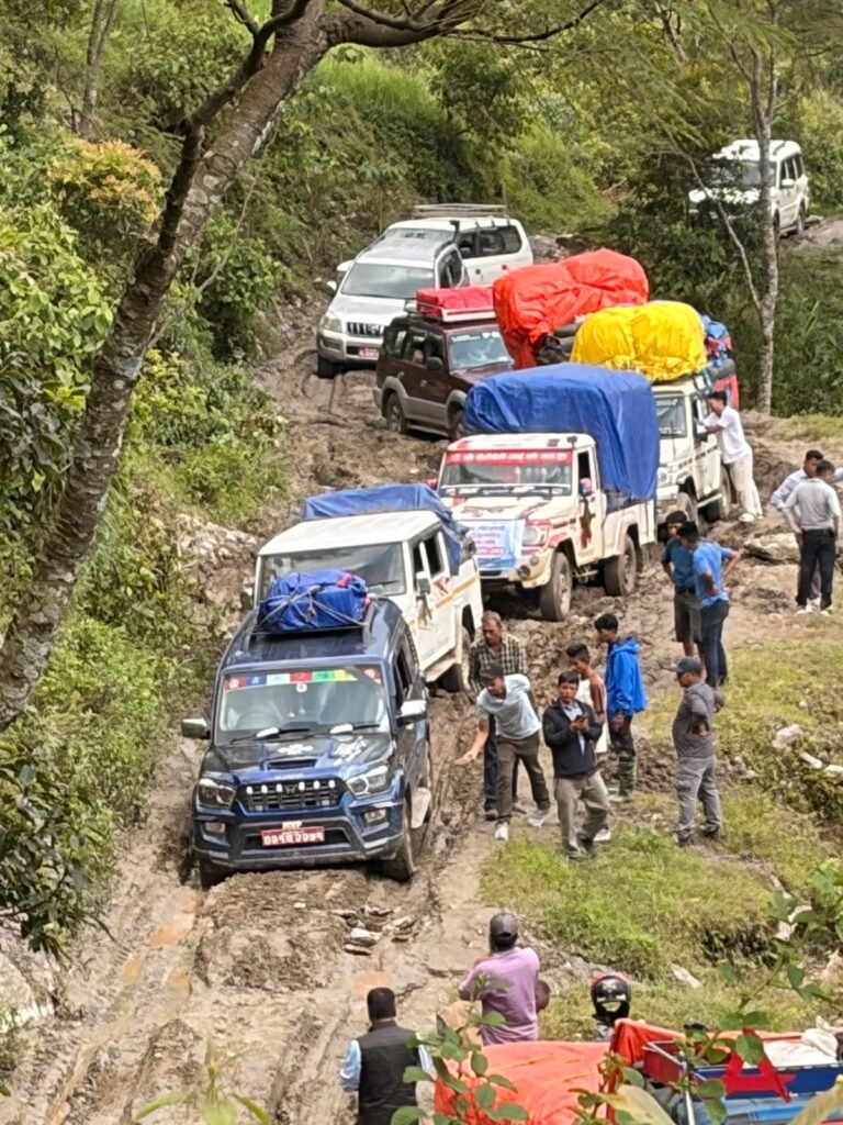 Convoi de véhicules chargés de l'aide sur une route de montagne boueuse